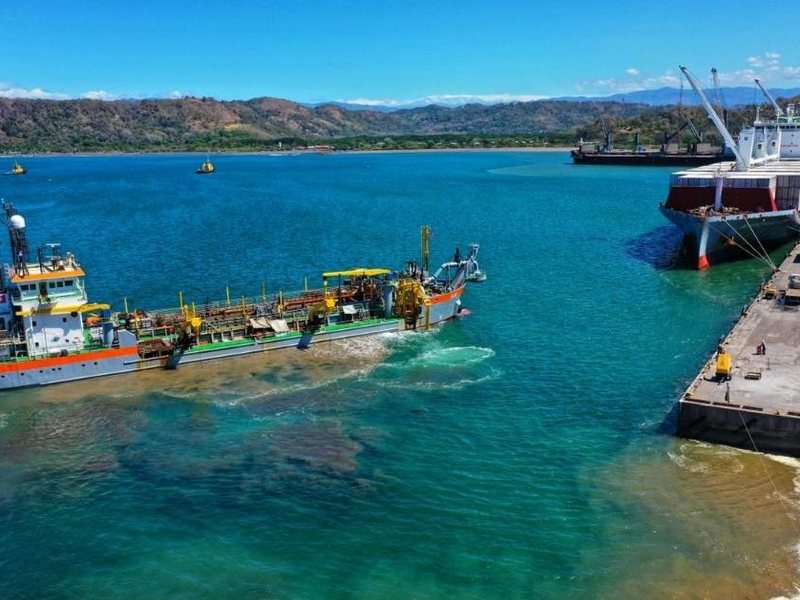 Draga de tolva trabajando junto al muelle